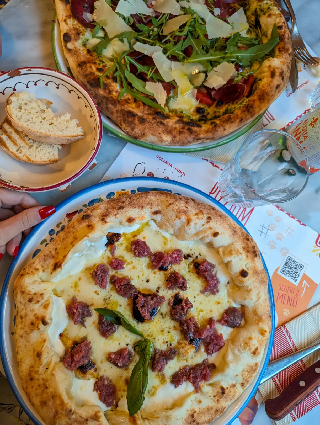 Two Neapolitan pizzas set on the restaurant table