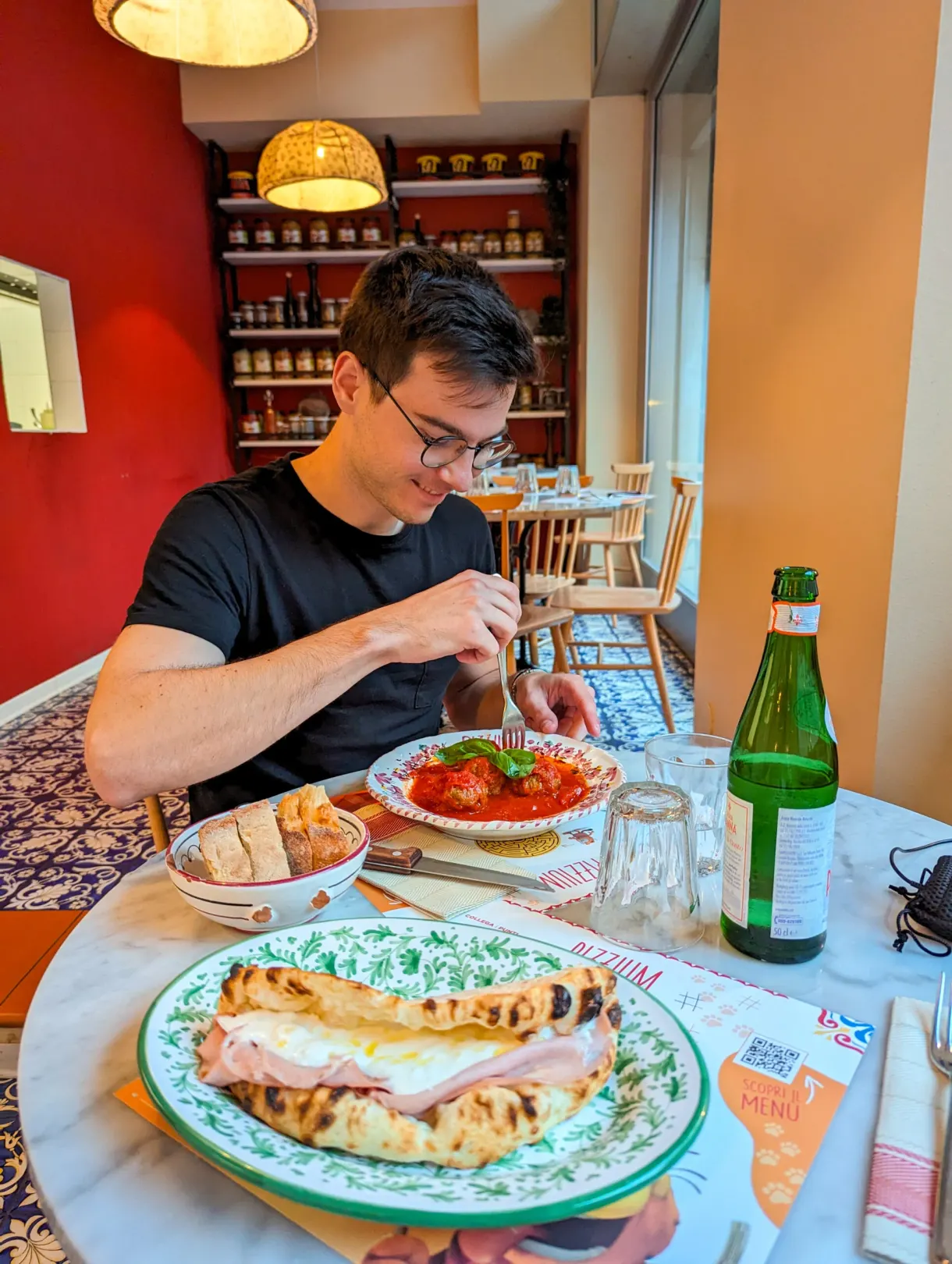 Diner at the table in front of Italian dishes and a beer