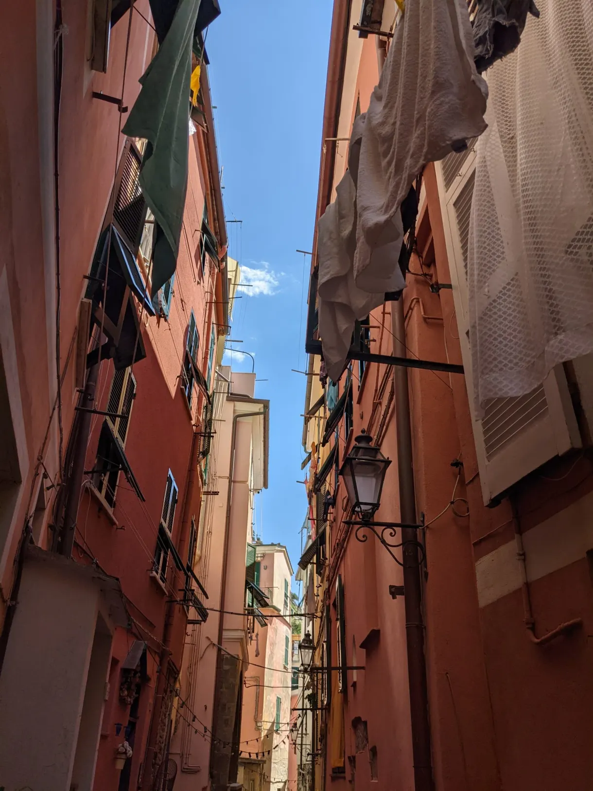 Linge étendu entre les façades rouges d'une ruelle étroite
