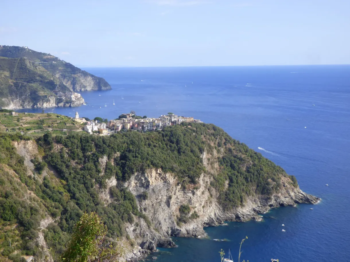 Village accroché à la falaise, aperçu depuis les hauteurs boisées