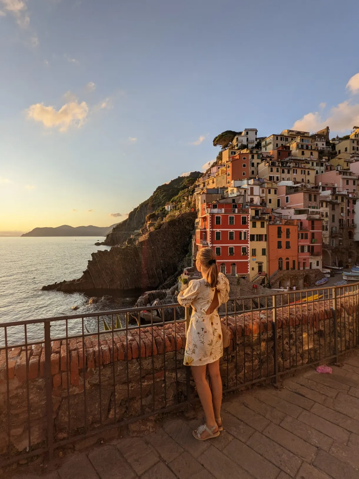 Femme photographiant le coucher de soleil depuis la terrasse