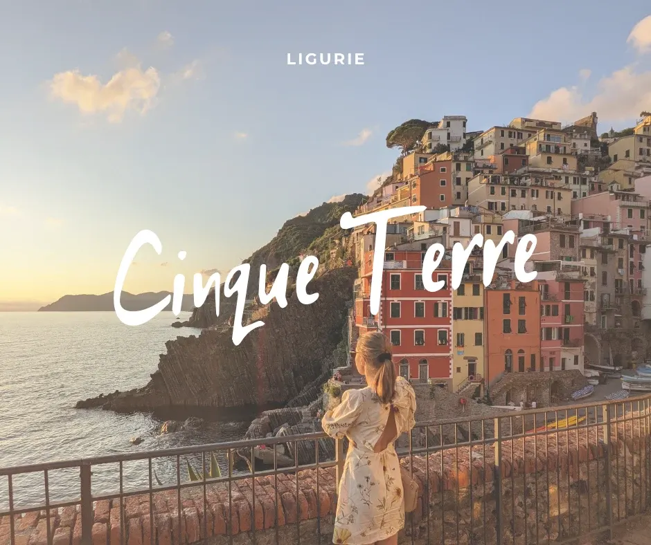 Femme en robe fleurie devant Riomaggiore au soleil couchant