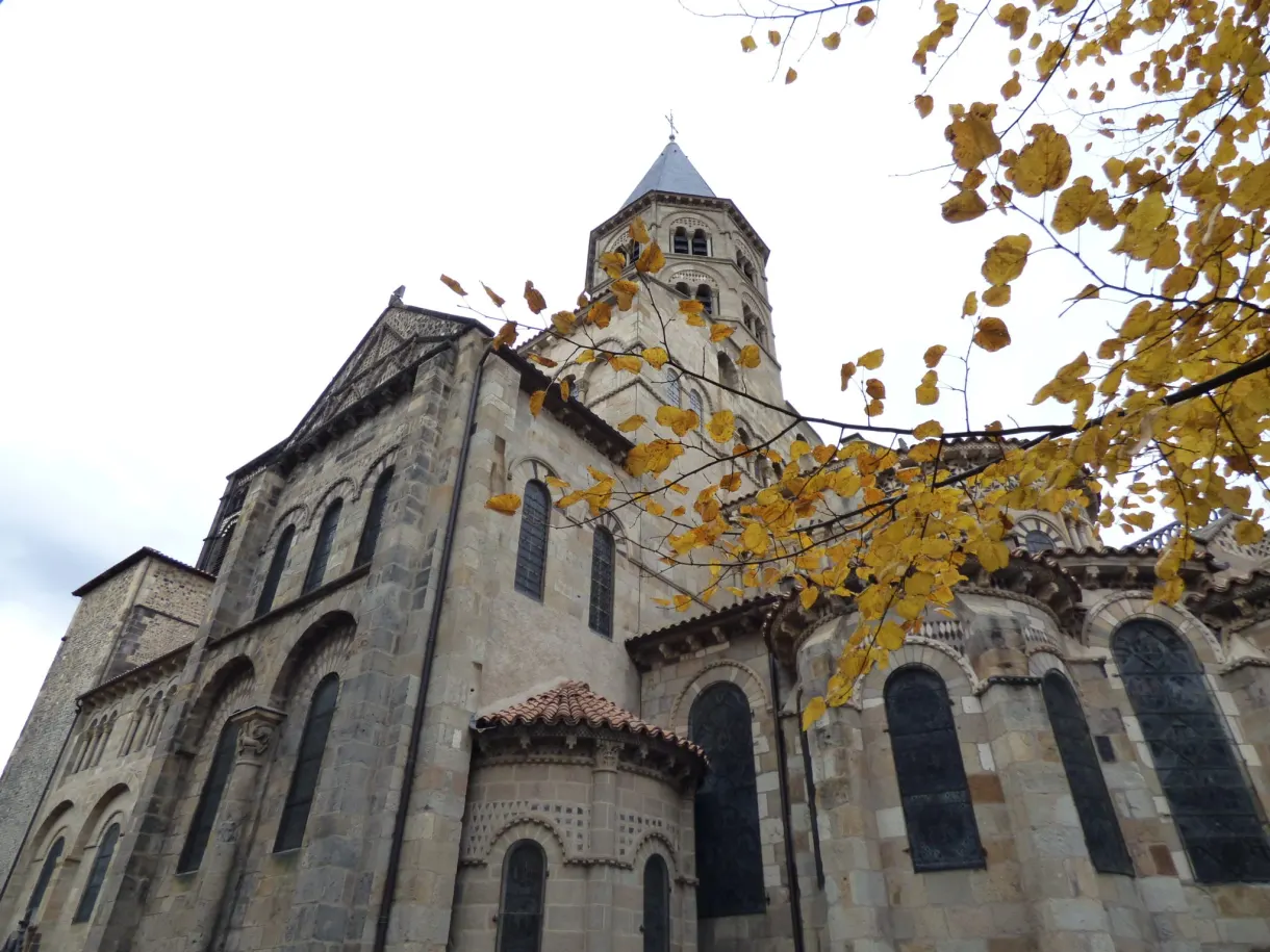 Romanesque apse of the basilica framed by yellow leaves