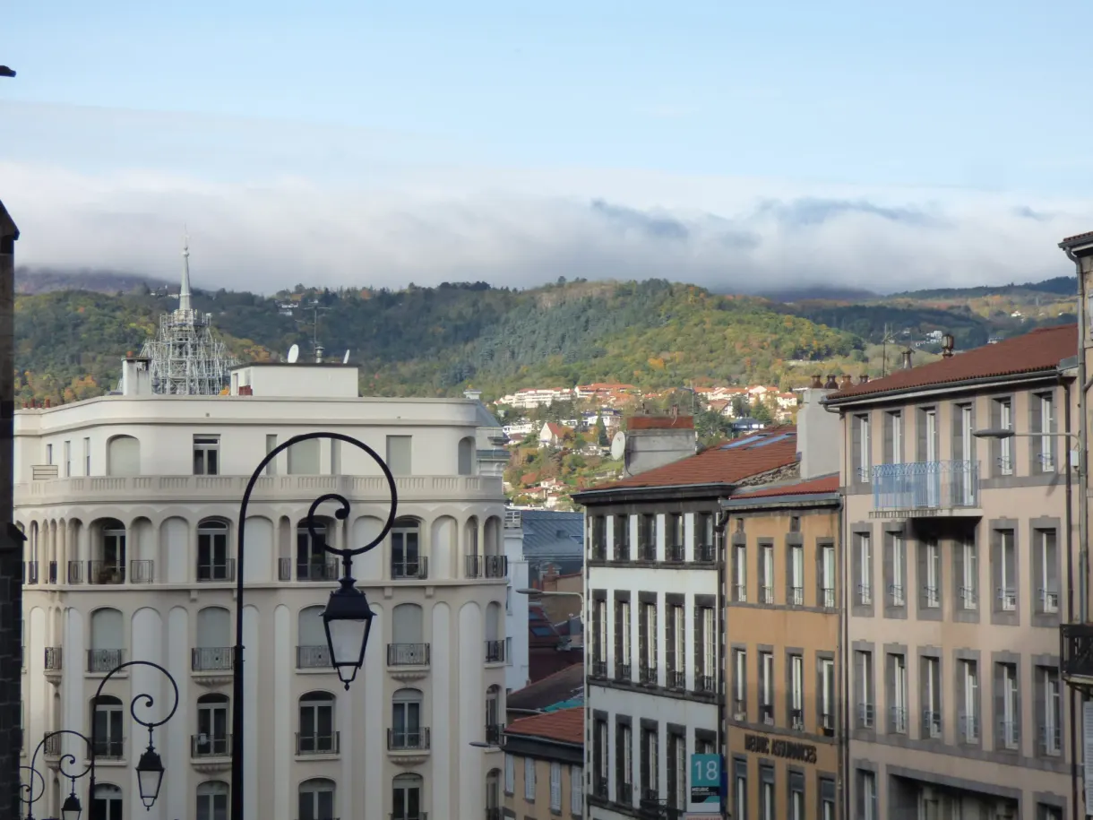 Rooftops of the city centre and wooded hills on the horizon