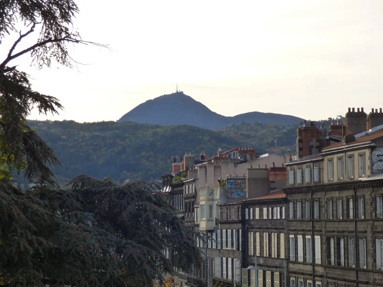 Puy de Dôme glimpsed at the end of a row of buildings