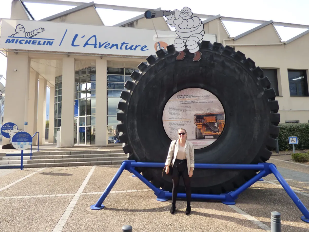 Giant tyre and visitor in front of the entrance to L'Aventure Michelin