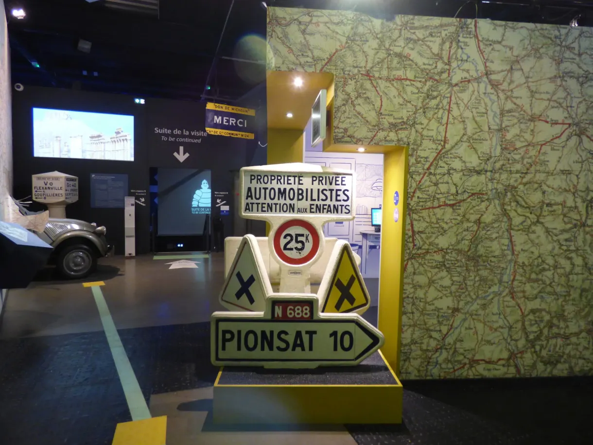 Old road signs standing in front of a wall map