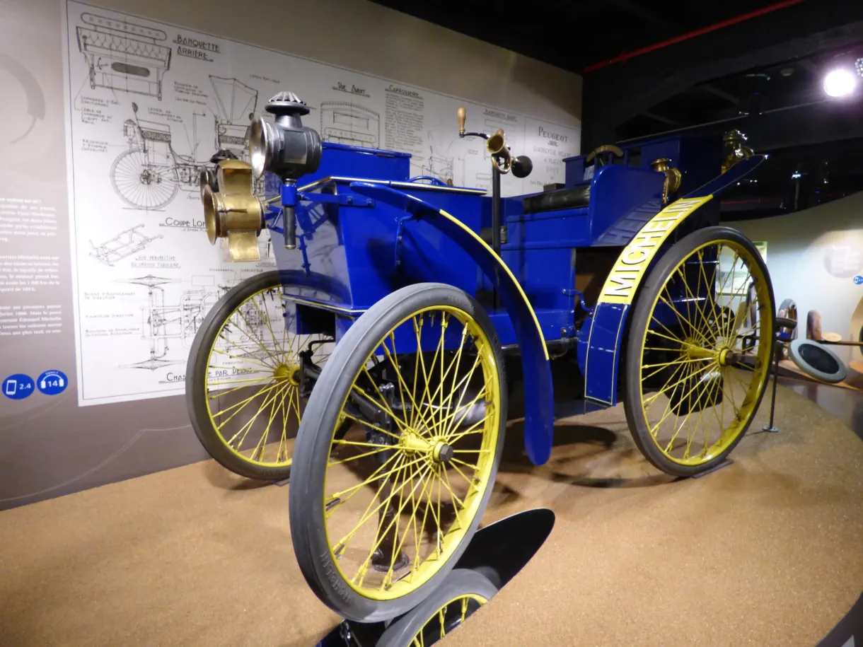 Blue car with yellow spoked wheels beneath its original drawings