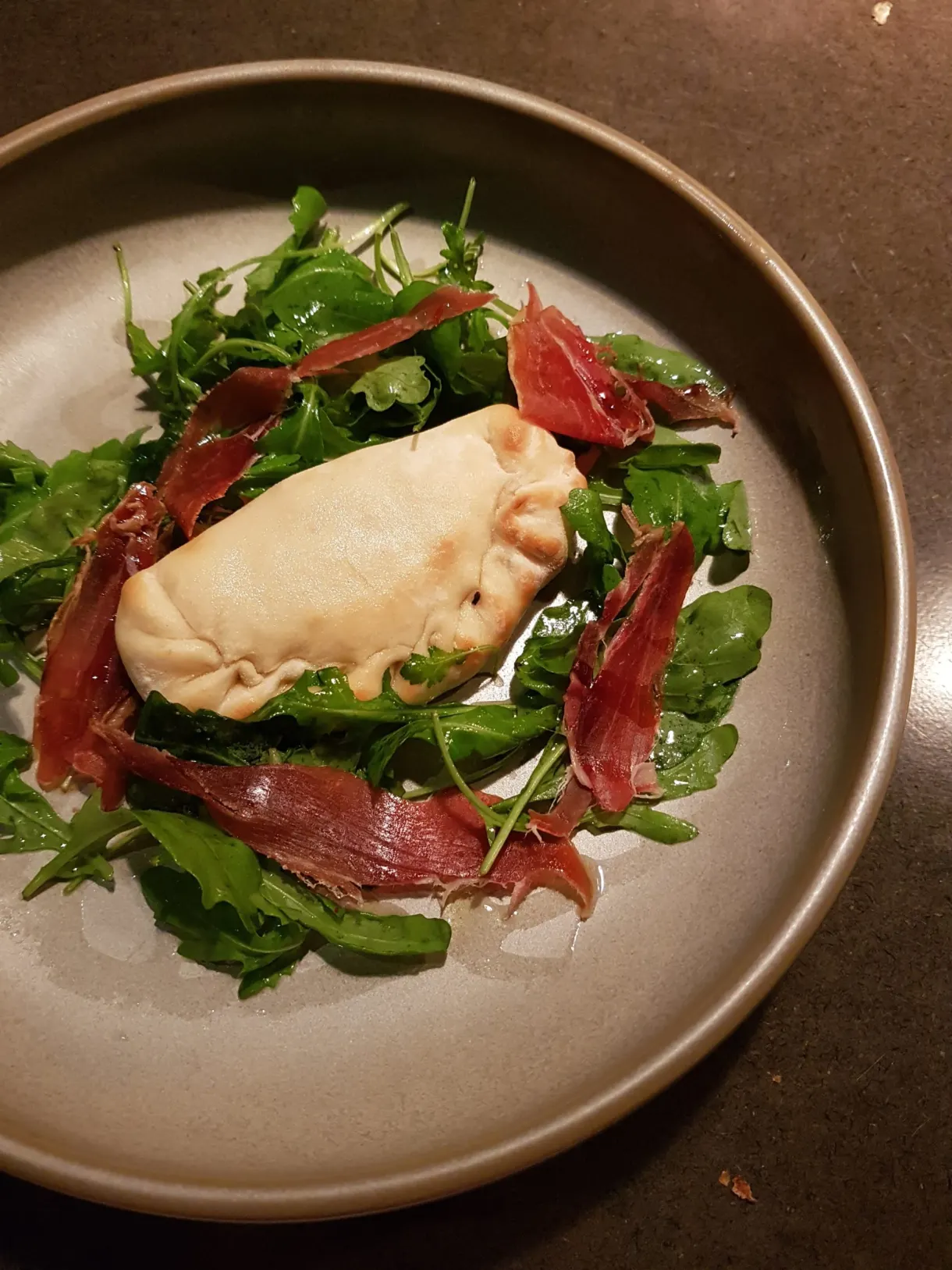 Golden puff pastry and cured ham on a bed of rocket