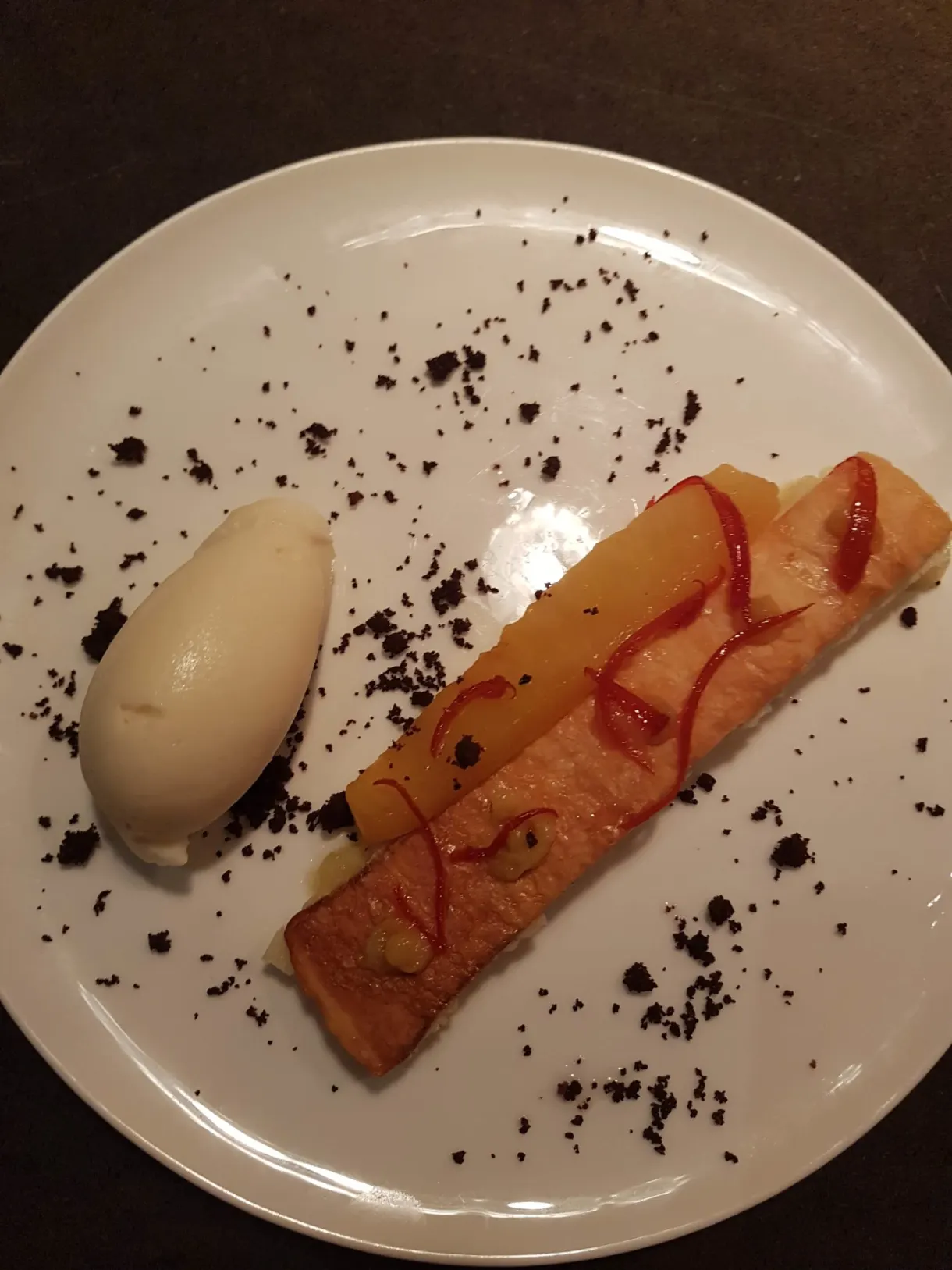 Thin tart and a quenelle of ice cream on a streak of coulis