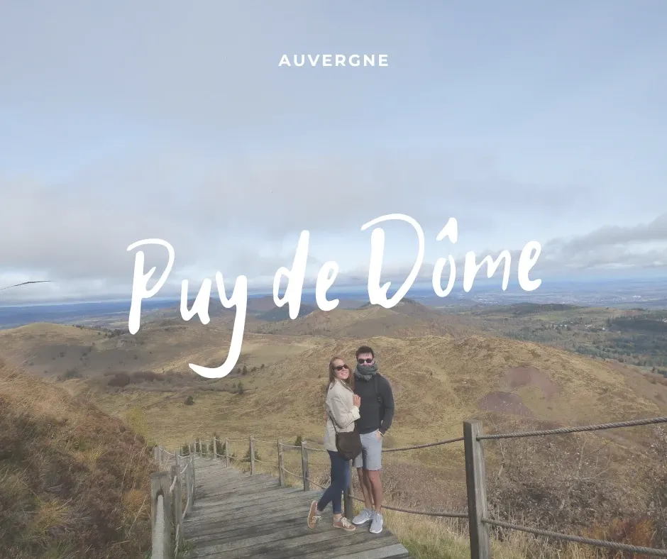 Couple embracing on the wooden walkway facing the Chaîne des Puys