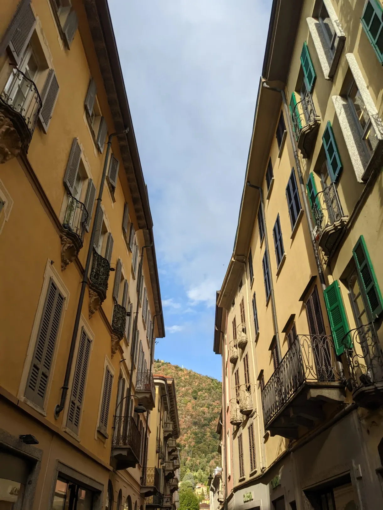 Ruelle étroite entre des façades jaunes aux volets verts