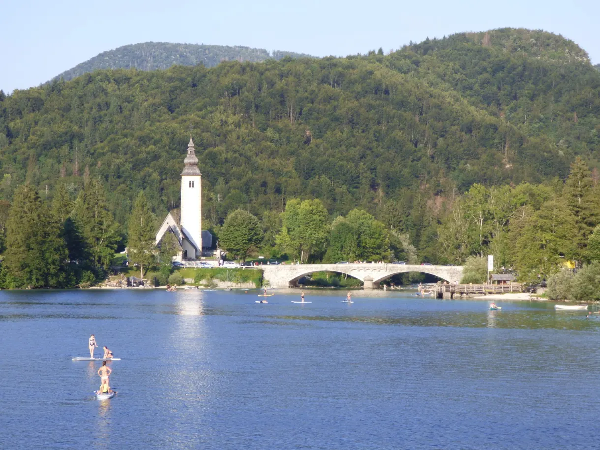 Clocher blanc et pont de pierre au bout du lac