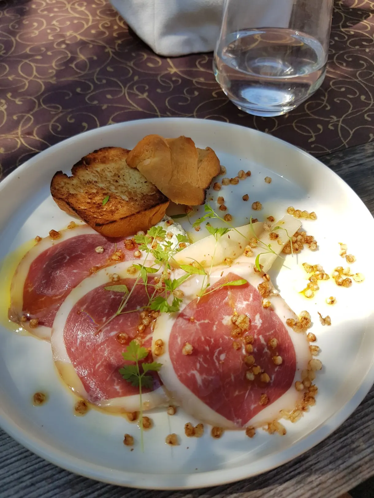 Carpaccio et croûtons dressés dans une assiette blanche