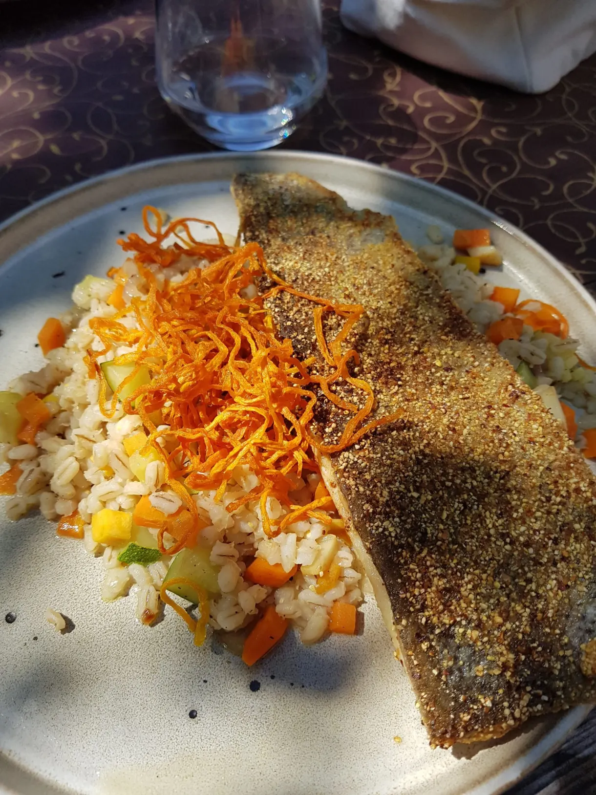 Filet de poisson croustillant servi sur un risotto