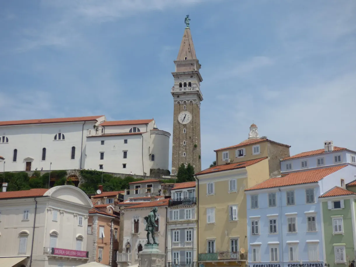 Stone campanile towering over the pastel houses of the square