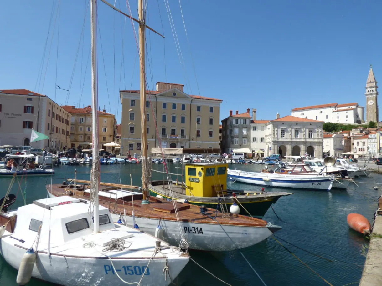 White sailing boats moored in front of the ochre facades of the harbour