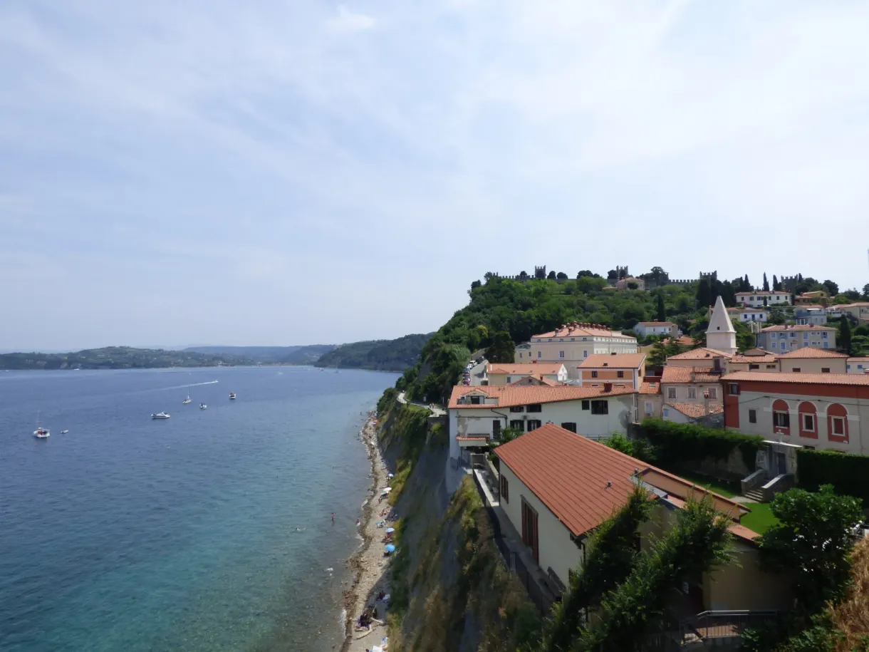 Houses clinging to the cliff above a pebble beach