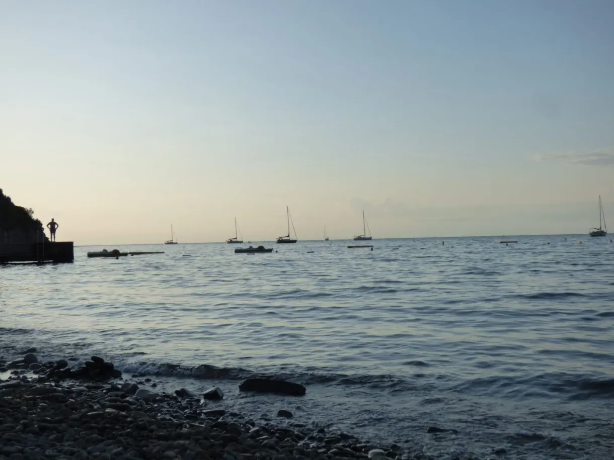 Pebbles and sailing boats at anchor in the evening light