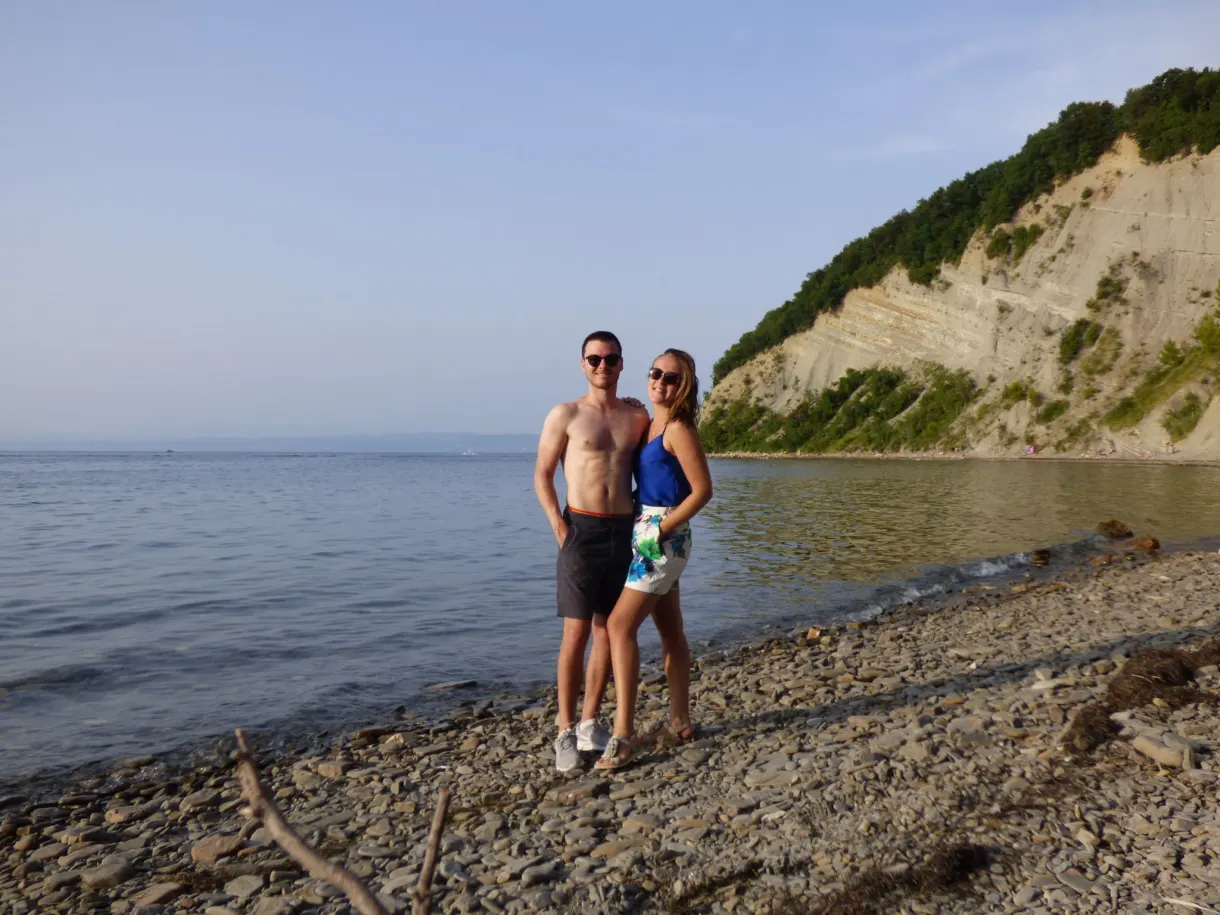 Couple posing on the pebbles below the ochre cliff