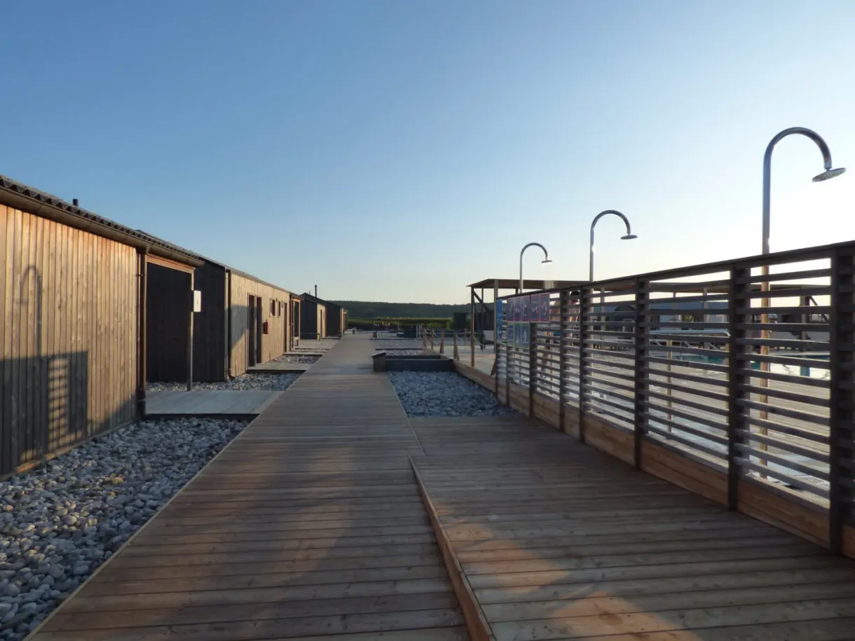 Row of wooden cabins and outdoor showers at the spa