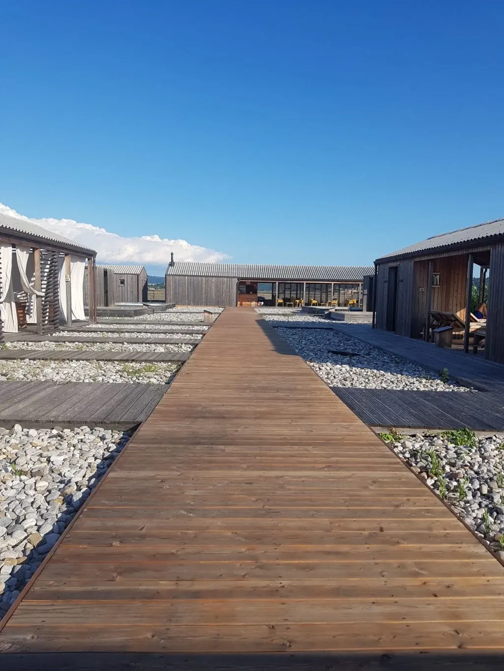 Wooden walkway running between the spa cabins