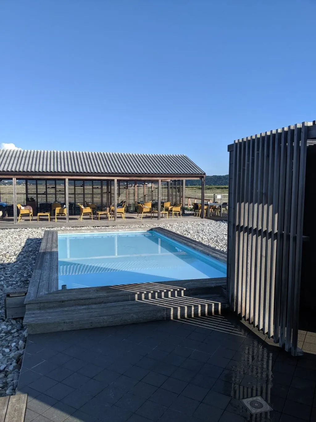 Pool and pavilion sheltering yellow armchairs