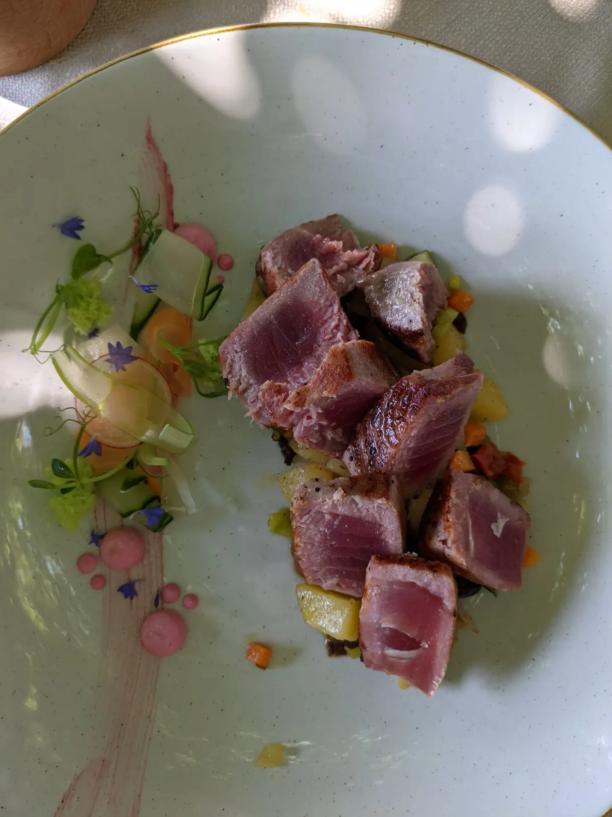 Cubes of seared tuna and glazed vegetables on the plate