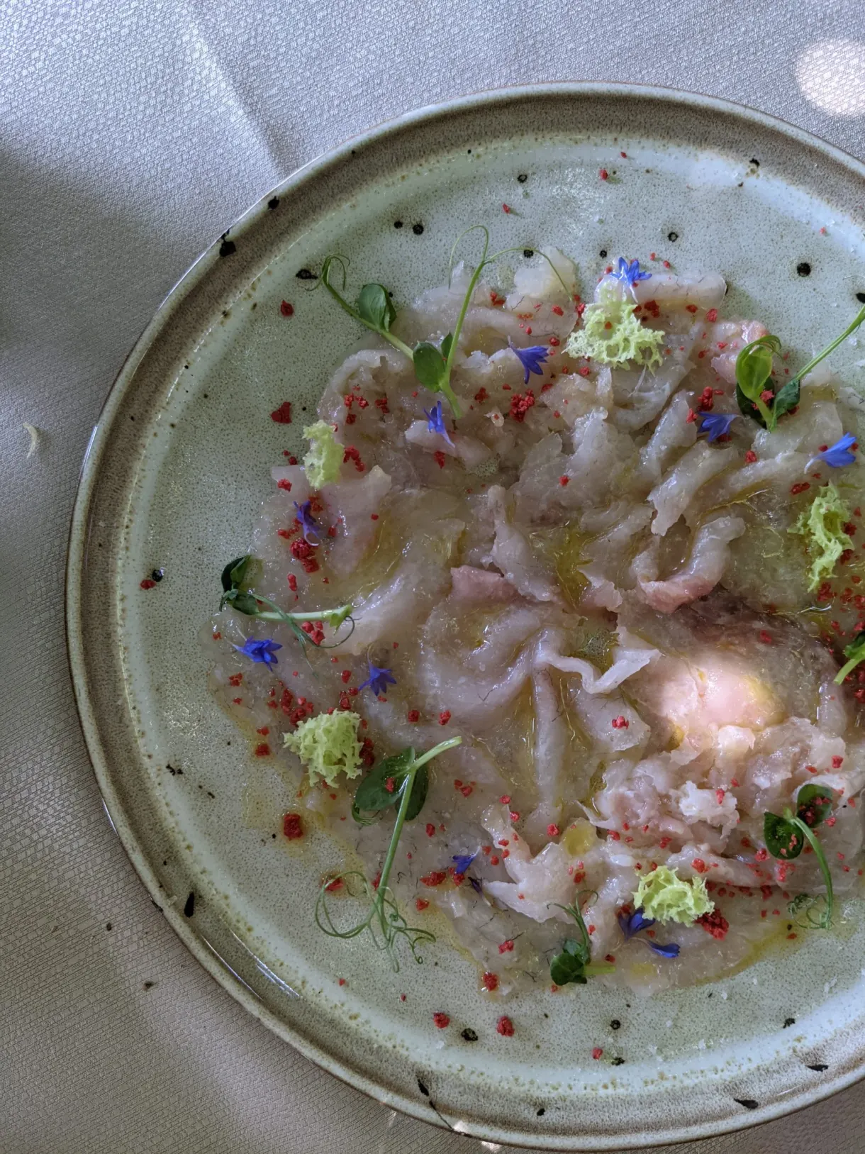 Fish carpaccio scattered with edible flowers