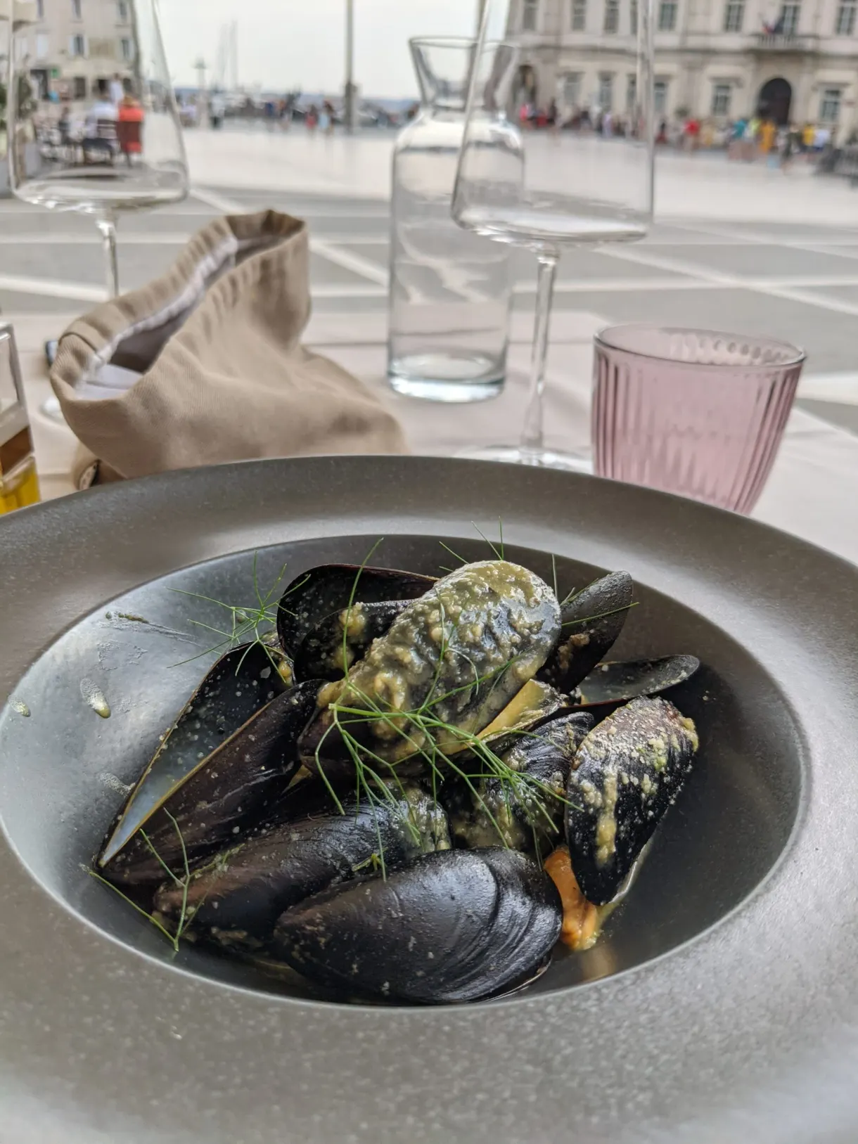 Deep dish of mussels served facing the quay