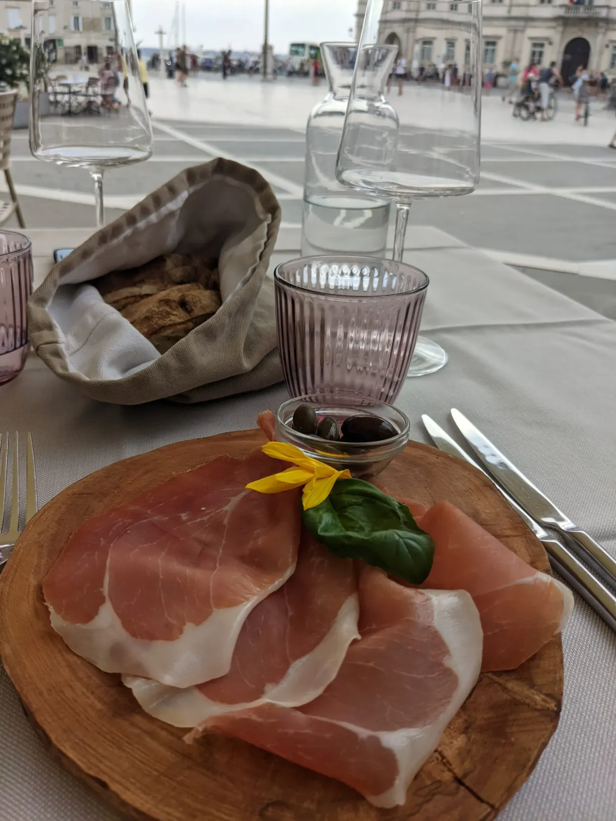 Thin slices of cured ham on a wooden board