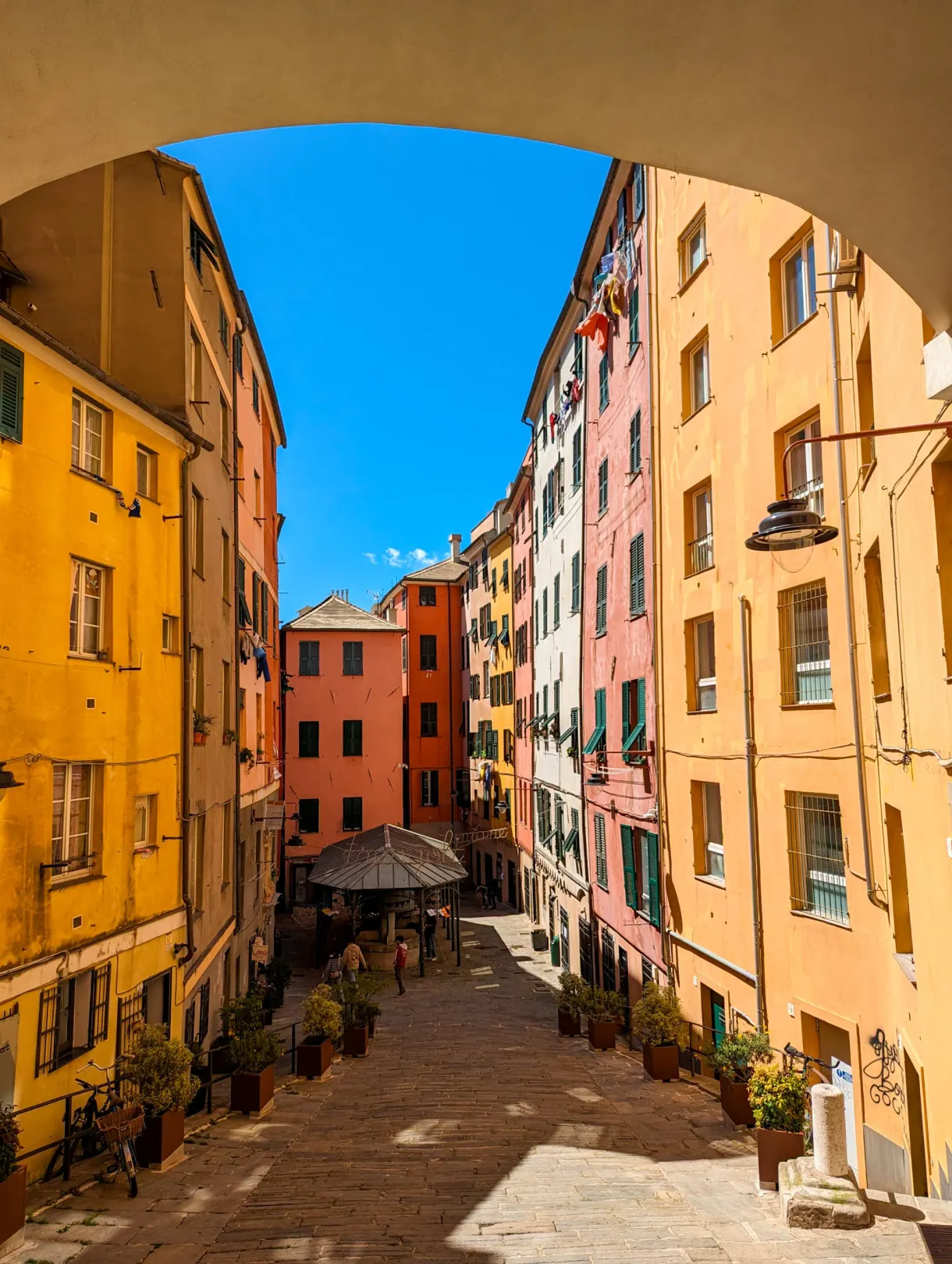Stone arch opening onto a lane with colourful facades