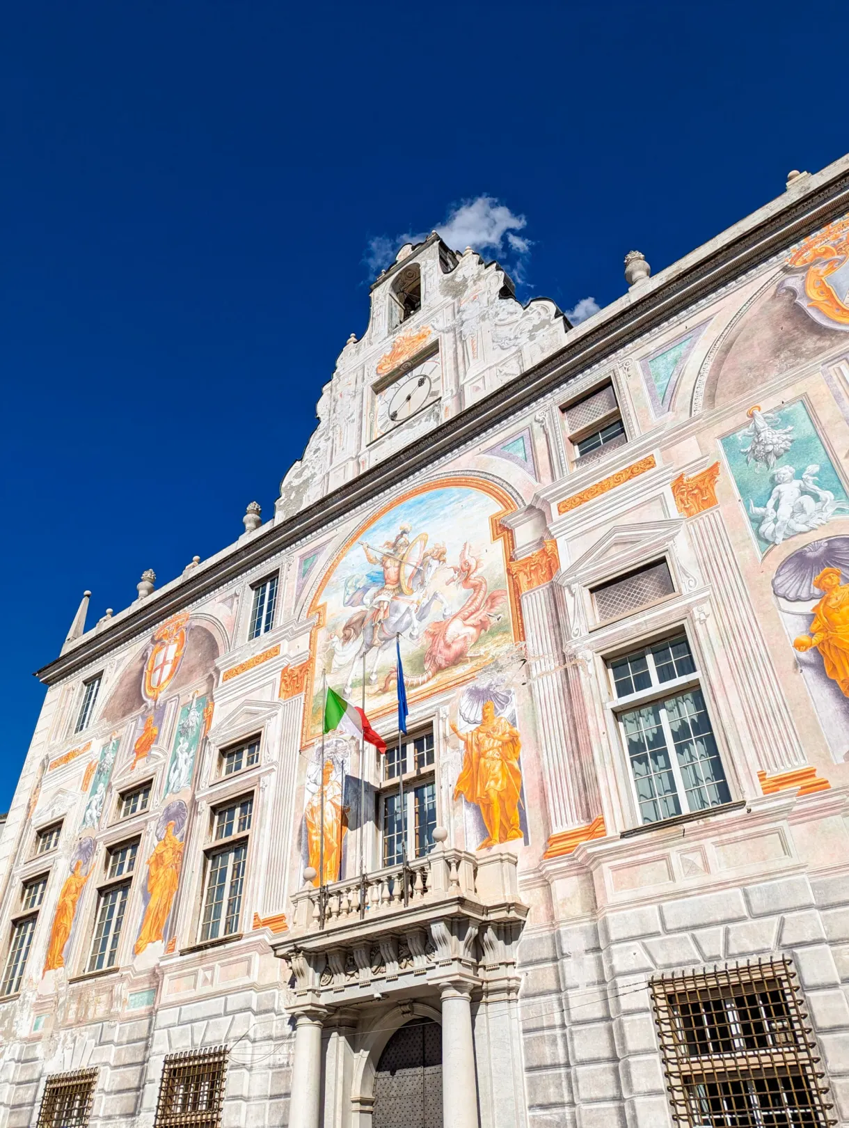 Palace facade covered with painted frescoes and flags