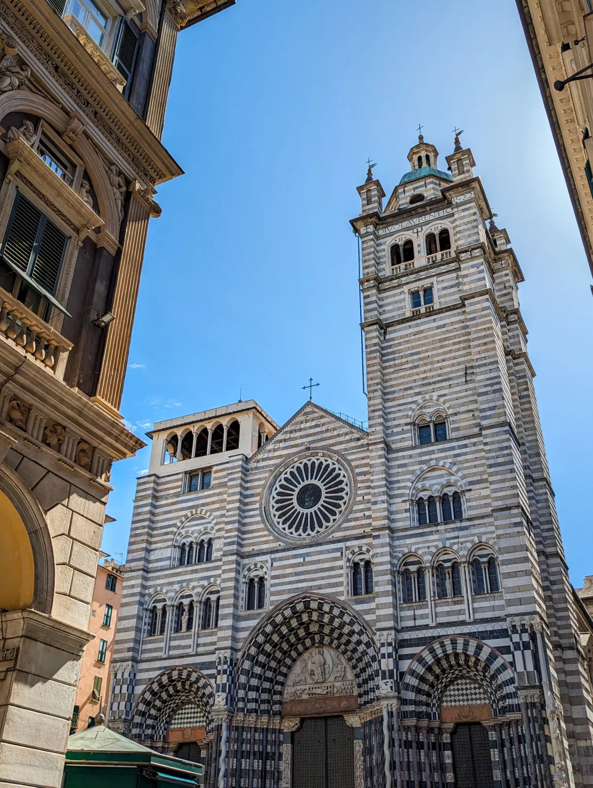 Black and white striped marble facade of the cathedral and its campanile