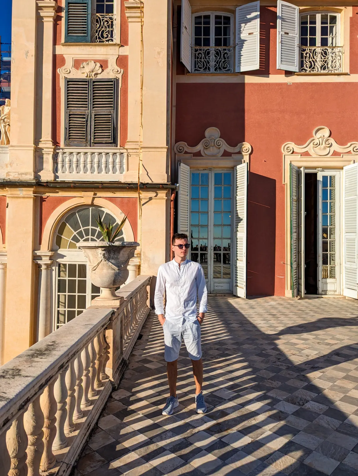 Man walking on the balustraded terrace of the pink palace