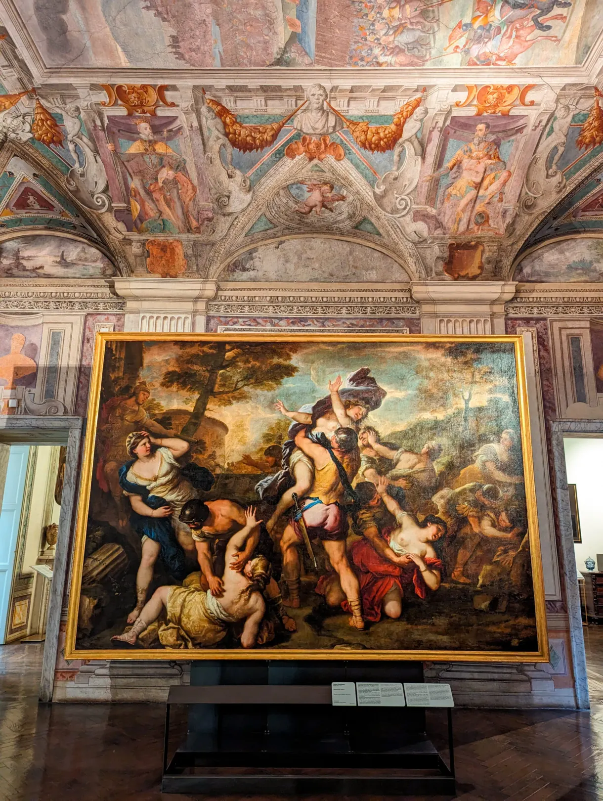 Large master painting shown beneath a frescoed ceiling