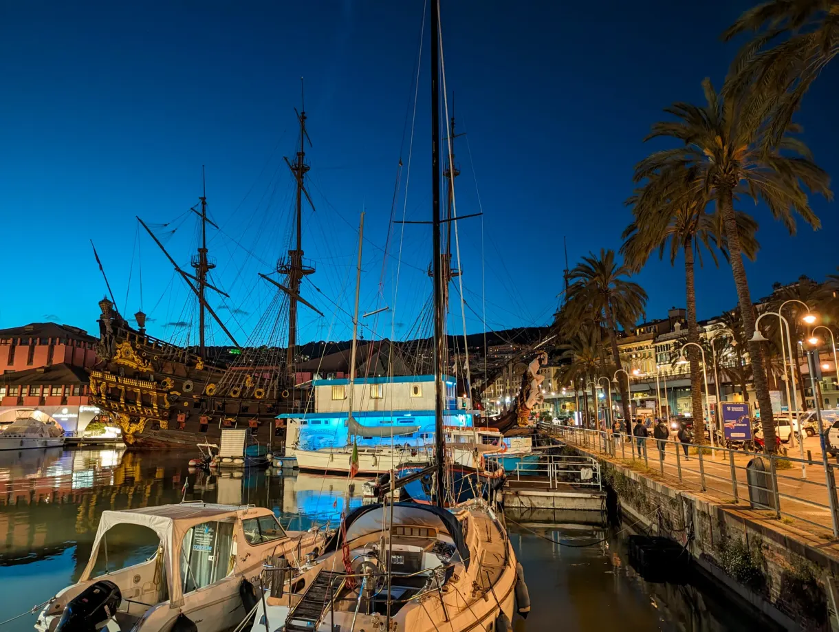 Galleon and sailing boats moored along the palm lined quay