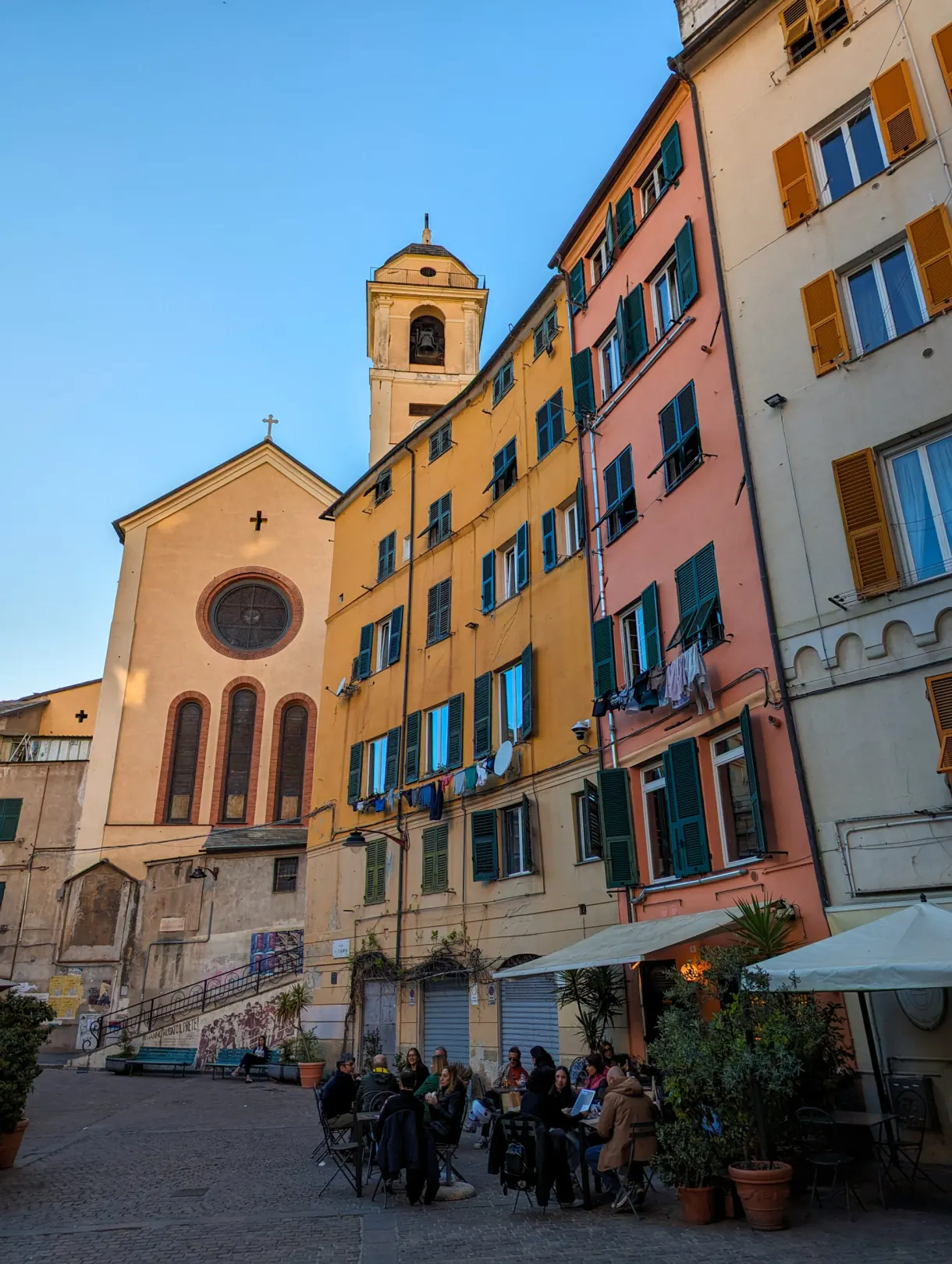 Pale stone church and colourful houses lining a square
