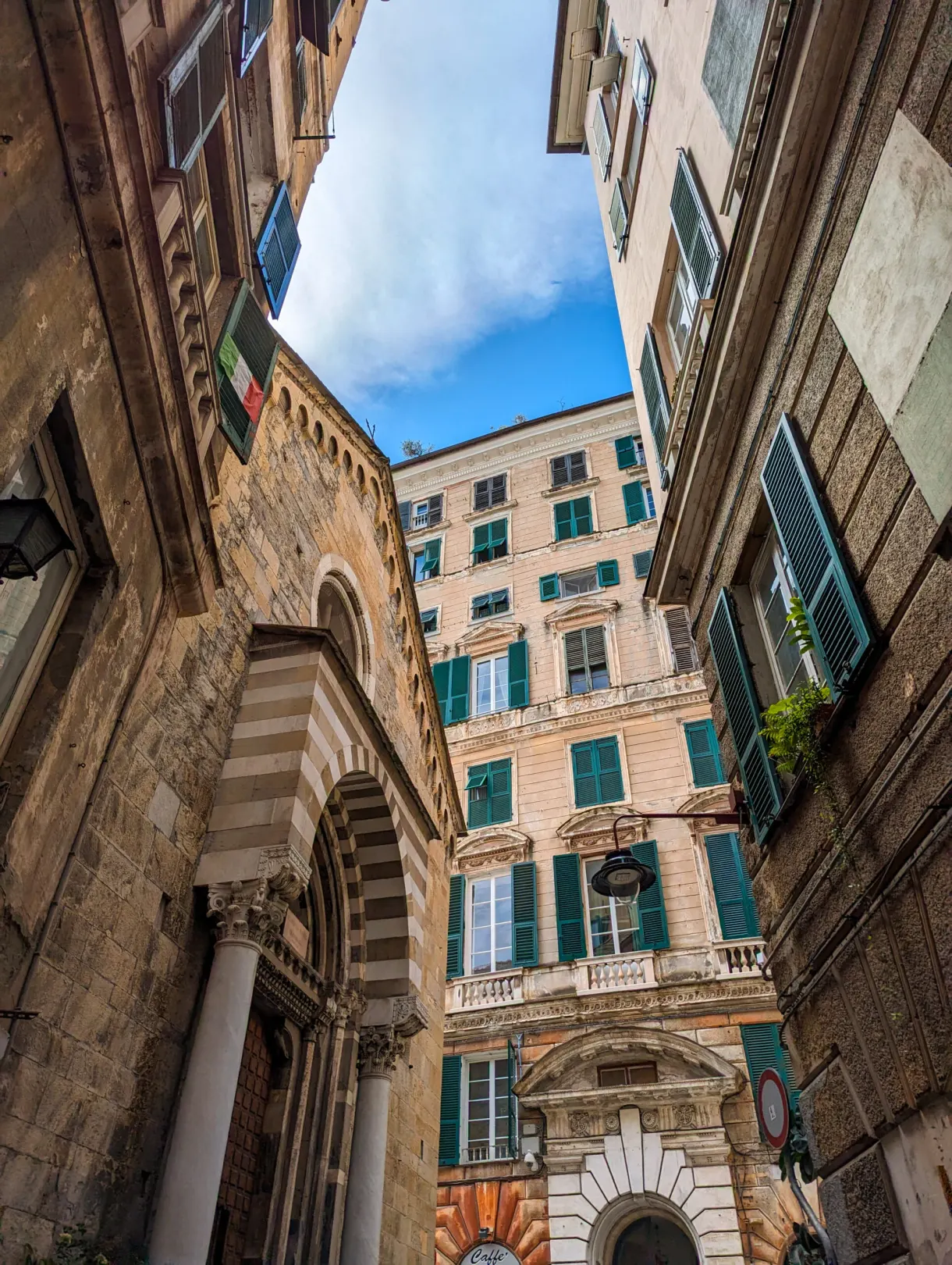 Low angle view of a columned porch wedged between two facades