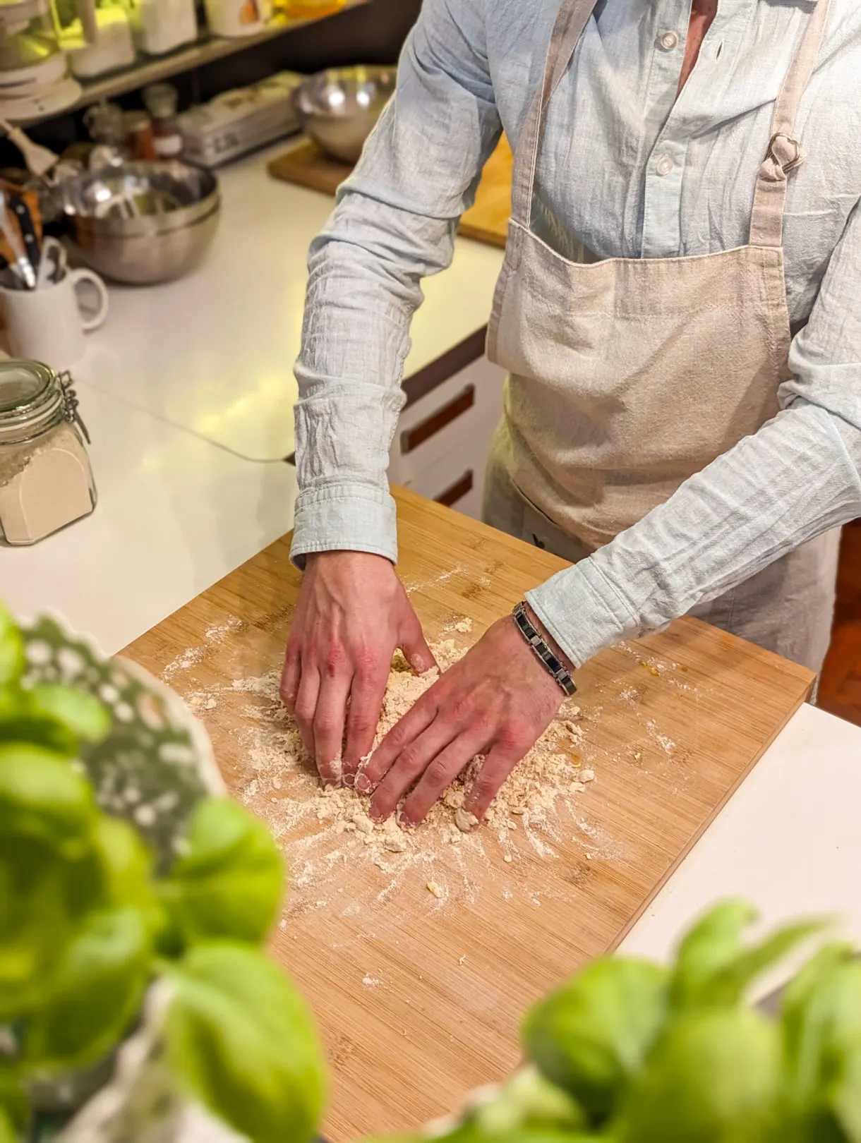 Hands gathering grated parmesan near basil leaves