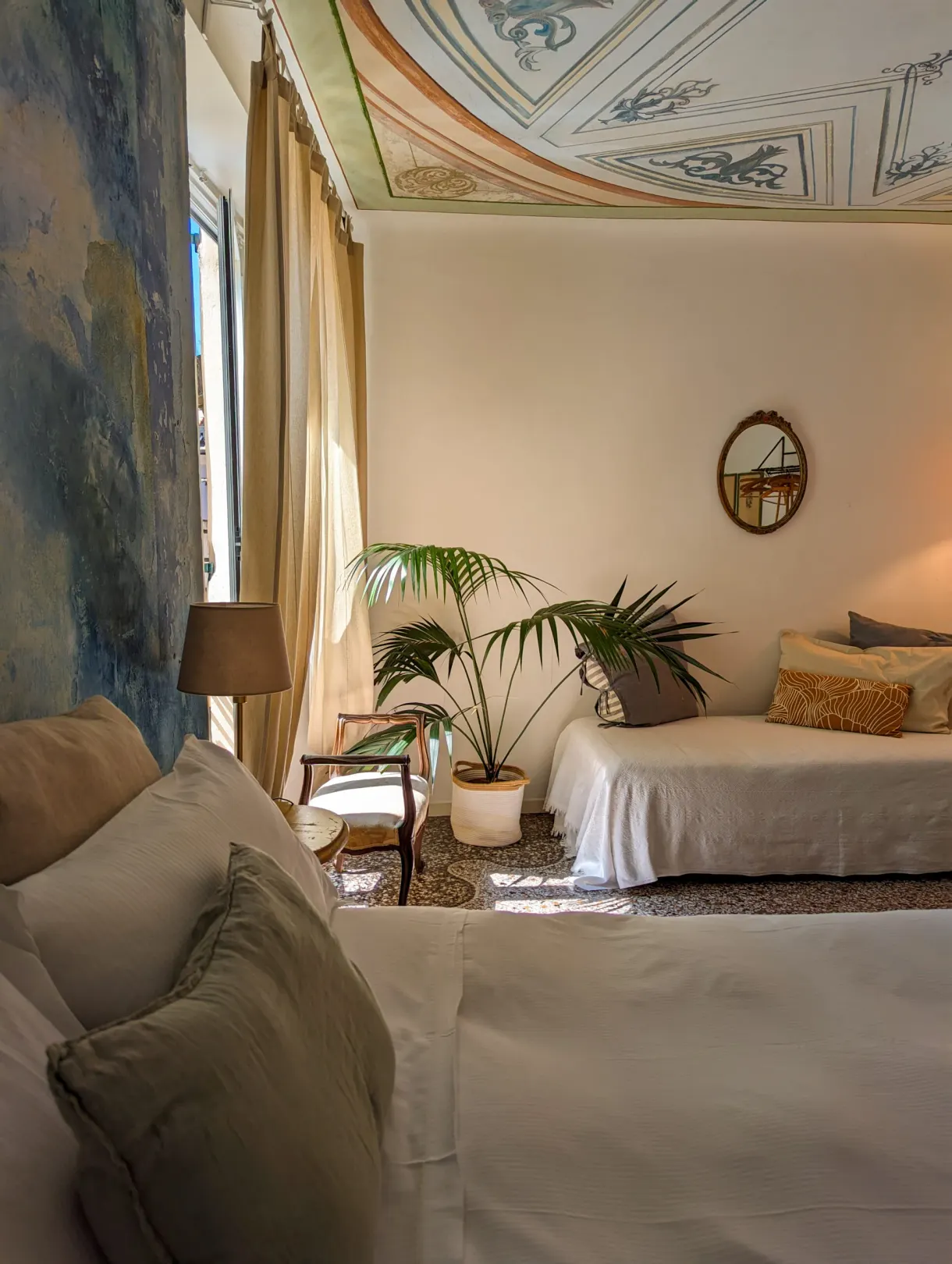 Sitting room with a painted ceiling, a pale sofa and green plants