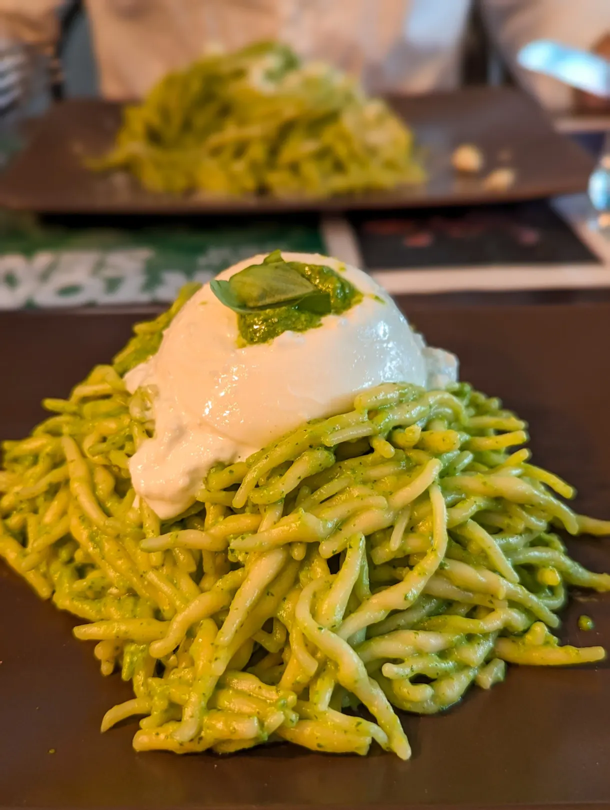 Pasta with pesto topped with a creamy burrata