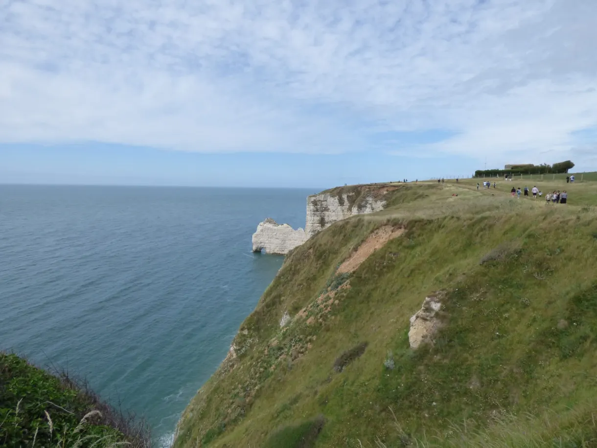Grassy plateau at the top of the cliff overlooking a dark sea