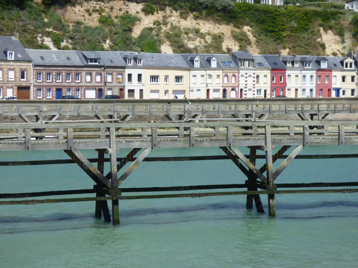 Wooden jetty in front of a row of colourful facades