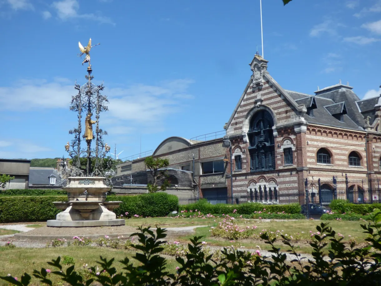 Flower garden and ornate spire in front of the Palais Bénédictine