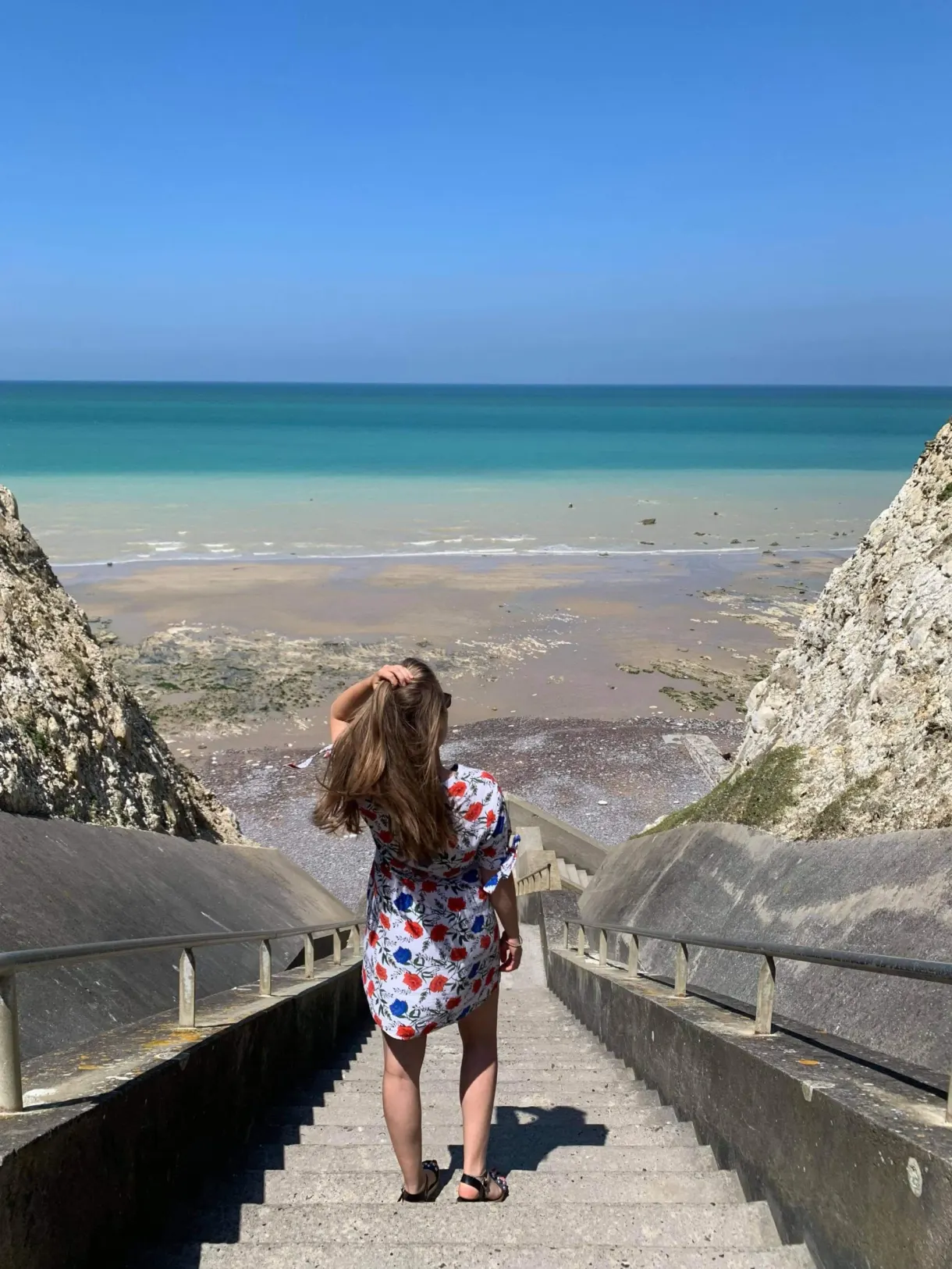 Woman in a floral dress looking at the foreshore from the valleuse staircase