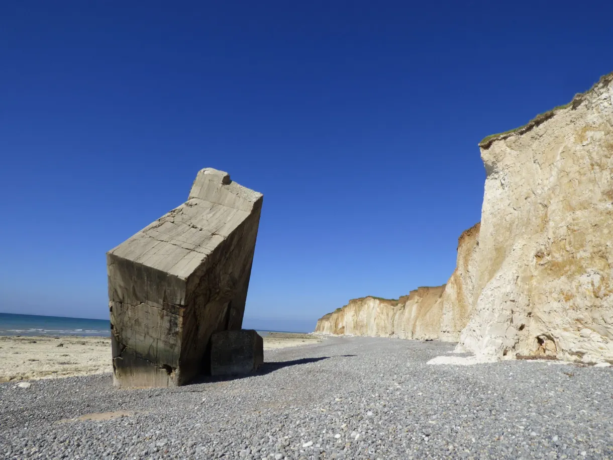 Block of a bunker toppled onto the pebbles at the foot of the cliff