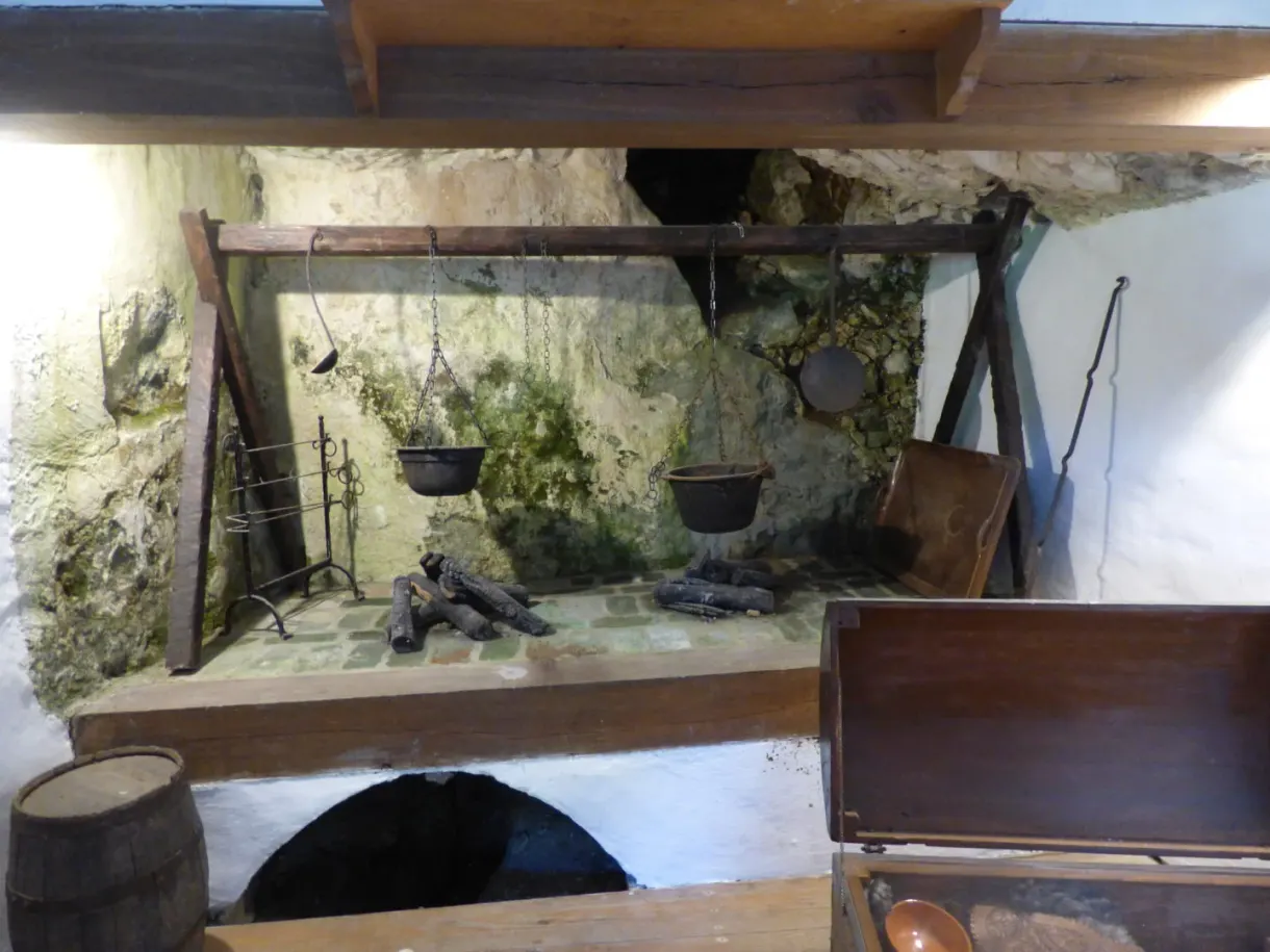 Old kitchen with cauldrons hanging above the hearth