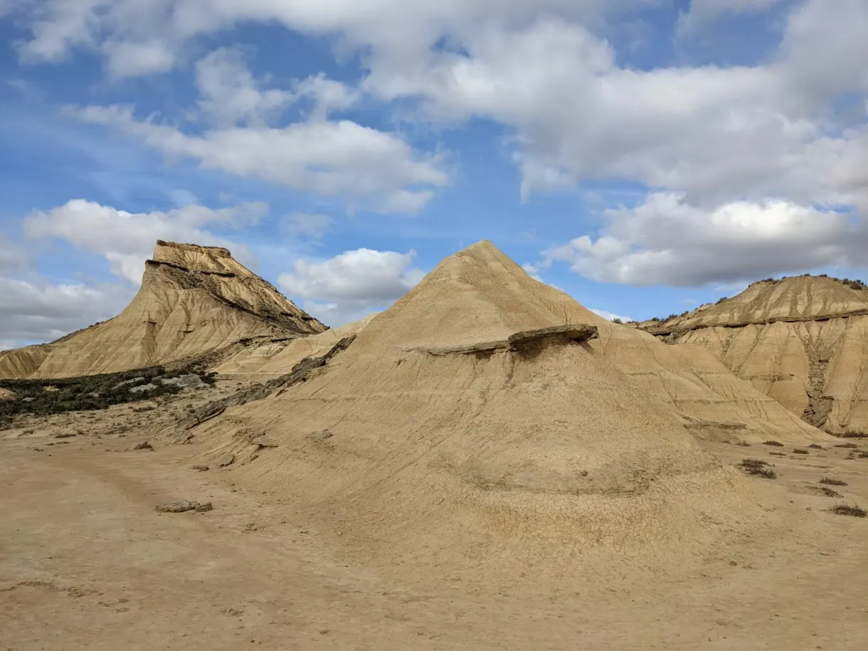 Conical mounds of pale clay under a mackerel sky