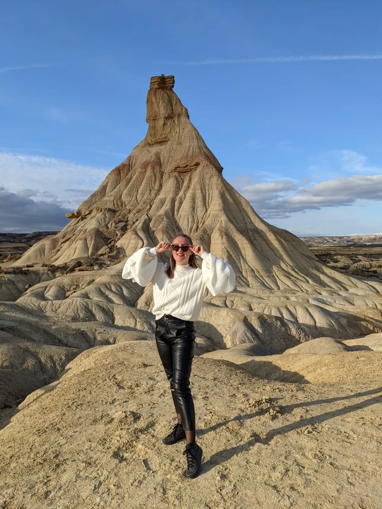 Arms raised on a promontory in front of the hoodoo